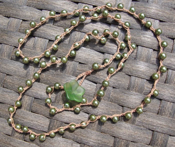 These are pretty glass faux pearls in an olive green color. This chain is made from thin cotton thread, not as thick as the cording. I used a glass flower and loop for the clasp.