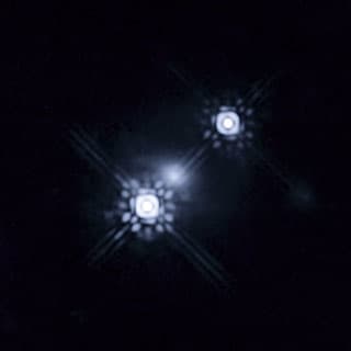 First-ever photo of an accretion disk around a quasar -- times two! The smudge in the middle is a galaxy whose gravitational lens created a magnified double image of the "accretion disc" around this distant black hole.