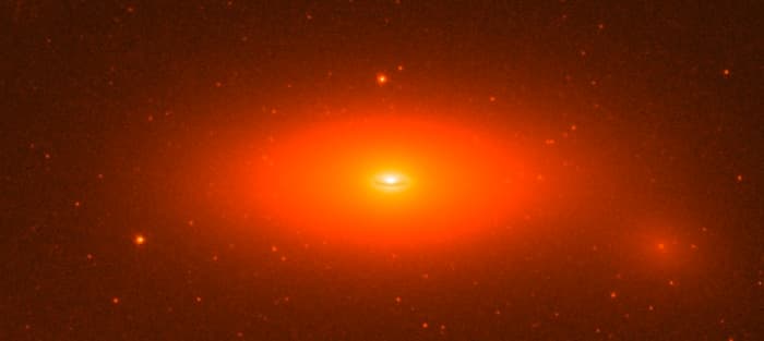 Even by supermassive standards, this black hole's is big: it's the mass of 17 BILLION suns, 14% of its whole galaxy's mass, and the black hole itself is as wide as 11 times Neptune's orbit.