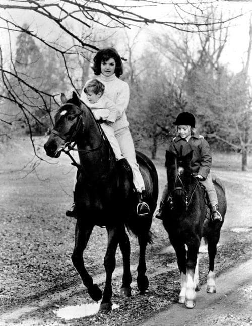 First Lady Jacqueline Kennedy and her children John F. Kennedy Jr. and Caroline Kennedy riding. Photograph distributed by the White House for the children's birthdays, 1962.