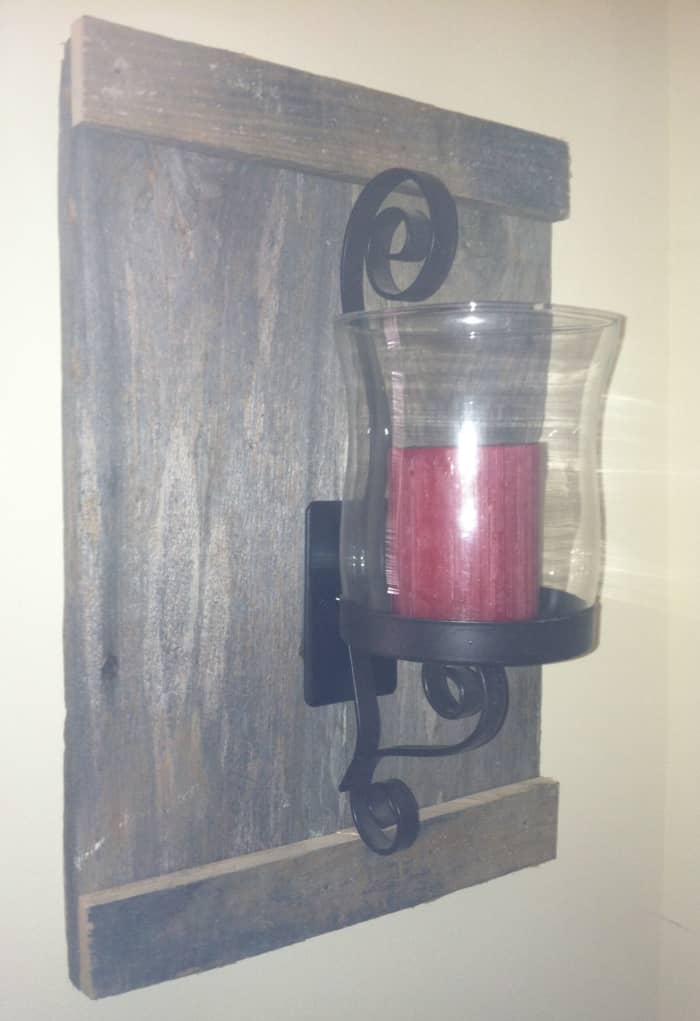 Free barn wood, thrown away, a thirty three cent sconce and and a twenty five cent glass globe together with a candle, a gift form a friend, came together to create this Hurricane lamp wall art for a grand total of fifty eight cents