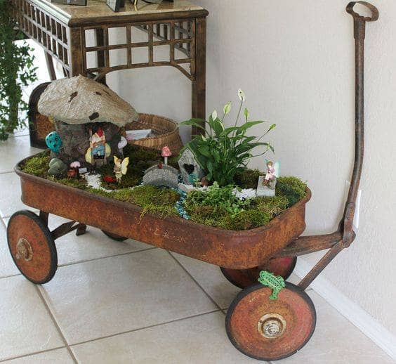 You need to drill holes in the bottom of the wagon if you are using outside where rain can overfill it. Inside, you can control the watering and can skip that step. Look at the use of one taller plant and then low moss for the garden.