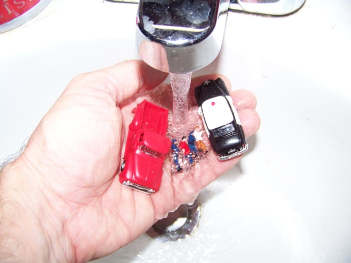 I just rinse small objects such as scale people, cars, and trucks to remove dust/dirt then blot them dry on a paper towel.