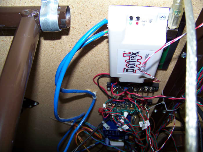 I mount my Digitrax PR3 computer interface, along with other electronic components, to the front bottom of the MDF board that makes the tabletop. This puts the electronic components close to the exposed wiring.