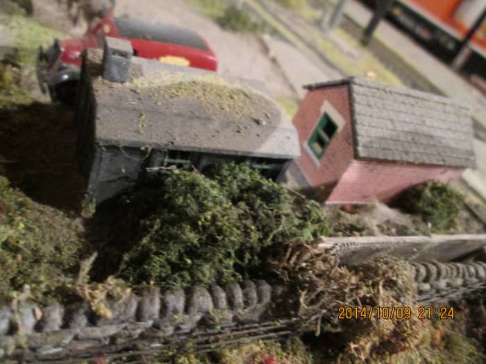 Undergrowth between the rear of the two huts and a farmer's wall (could be him with the Clydesdale talking to the stationmaster) - spot the barbed wire fence at bottom of picture?