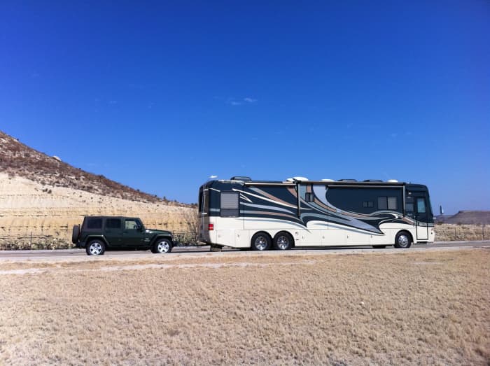 A large motorhome pulling a Jeep tow car "4-down," the typical preferred towing configuration of most motorhome owners.
