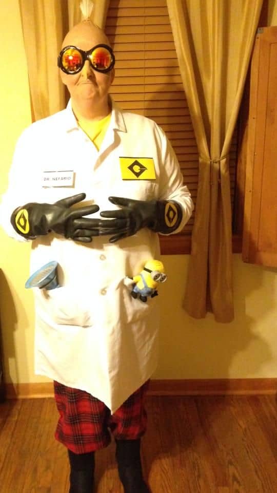 Goggles, name tag, lab insignia, rubber gloves, white lab coat, Minion doll, crazy plaid pants, and a pair of boots