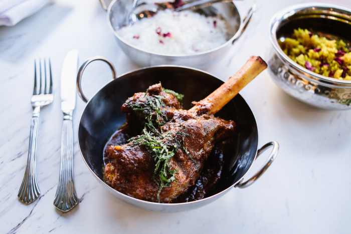 Lamb Shank Kosha Mangsho - Slowly braised lamb shank served with traditional mishti pulao with cashews.