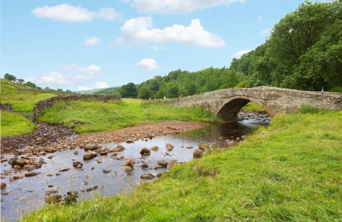 The River Cover where the road crosses the bridge to lead straight onward and upward for a distance