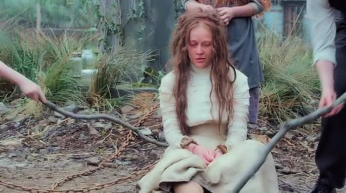 Jennifer Richardson (Elen Rhys) is poked with sticks by the island children while being held for ransom by the Erisden community in 'Apostle', a Netflix Original (2018).