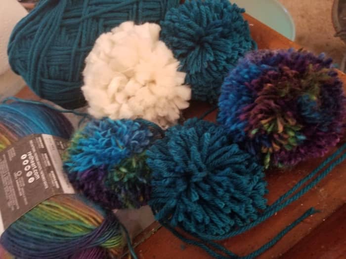 The white pompom is the jumbo weight- it ends up looking like a solid circle, the fibers immediately separate out. The multicolor is medium, requires much more yarn but is the softest. The solid blue is a #5. Less yarn, but less finished looking.