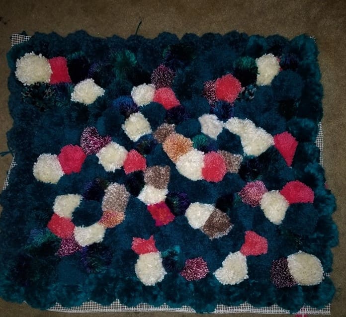 But before I turned the edges underneath and sewed them to hide the backing. Also, clearly I used more blue yarn than anything else, for two reasons: it matches the room it was going to live, and the blue yarn was on sale when I had to buy more.