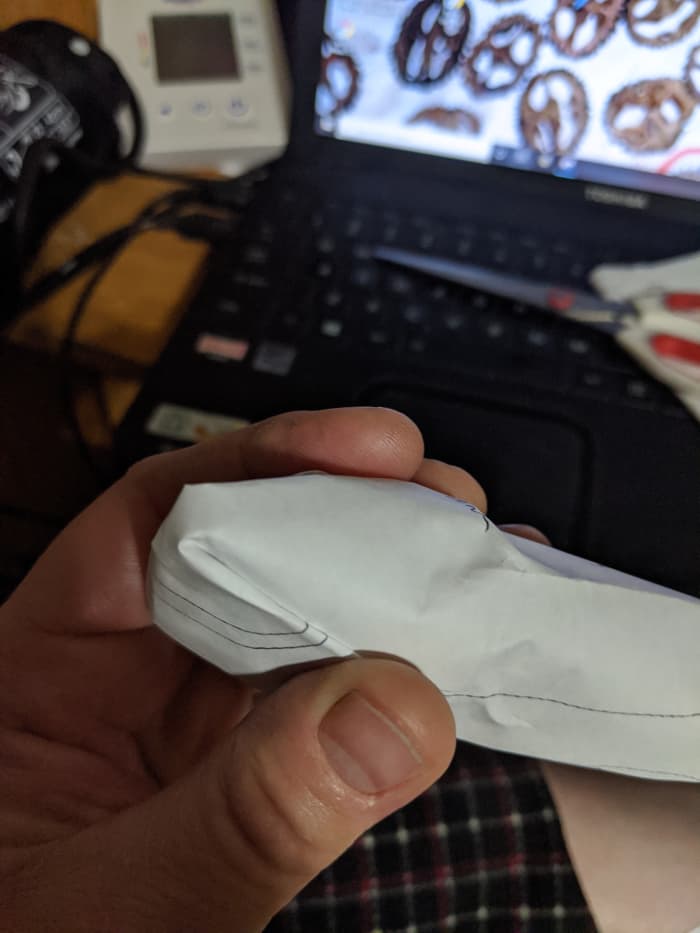 I'm going to fold the paper back and tape it. On the actual seat cover, I will top stitch the fold over on both sides.