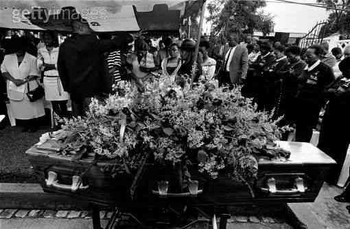 Priest holds service for AIDS victim in soweto, South Africa, 2003. It is estimated that about one thousand people or more die each day from this pandemic.