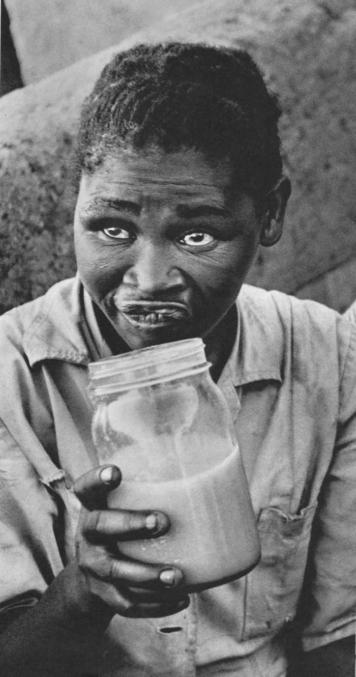 The poisoning of the beer Botha was talking about has long been an ongoing process in killing-off Africans in south africa. This battered woman is drinking the "Beer" made by the Apartheid regime and displays the slow poisoning effects over her.