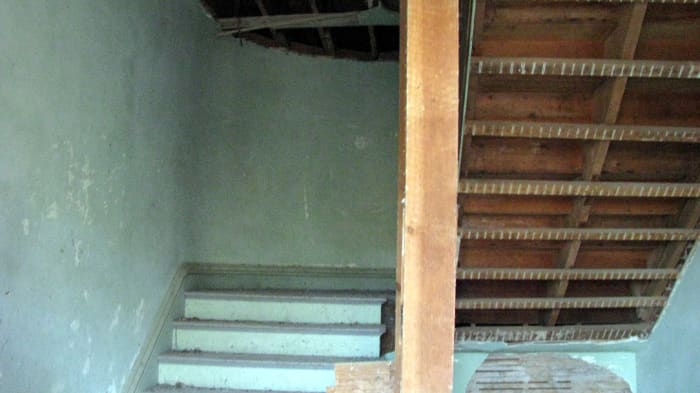 As you come in the front door, this is the stairway that you see. This is the main staircase that leads up to the second floor. The house also has rear stairways.