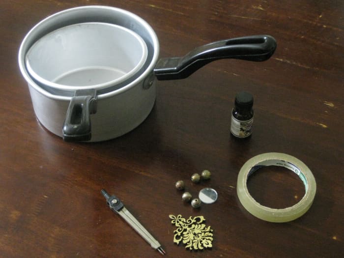 The materials for my gel candle-making project included a double saucepan, a bottle of fragrance oil, a geometric divider, cello-tape and embellishments.