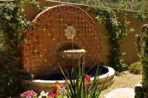 deep terracotta and tan tiles are the centerpiece for this peaceful water fountain and walled garden