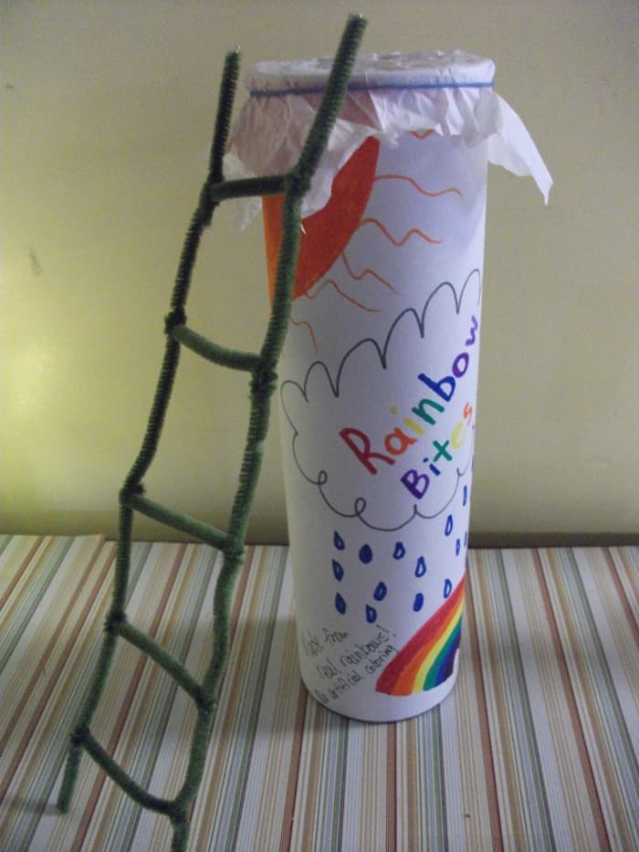 The leprechaun is lured to the trap by the promise of real rainbows bites. When he climbs onto the top of the container to grab a rainbow treat, the tissue paper covering the top breaks. The leprechaun is trapped in the Rainbow Bites.