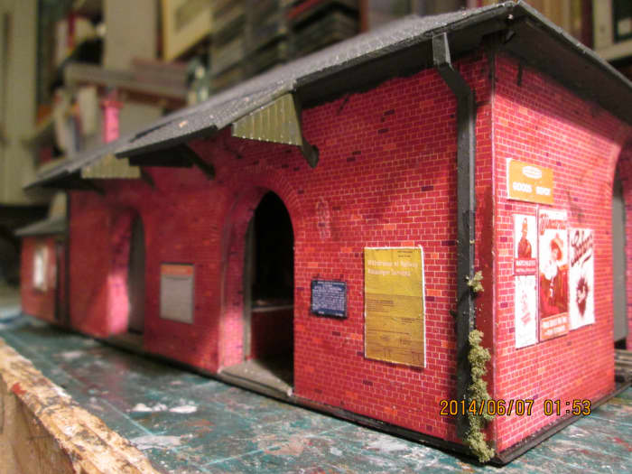 The two loading bay doorways looking from the nearside (roadside) corner. Note the closure poster and 'enamel' signs. Lichen at the corner represents weed growth from a damp wall