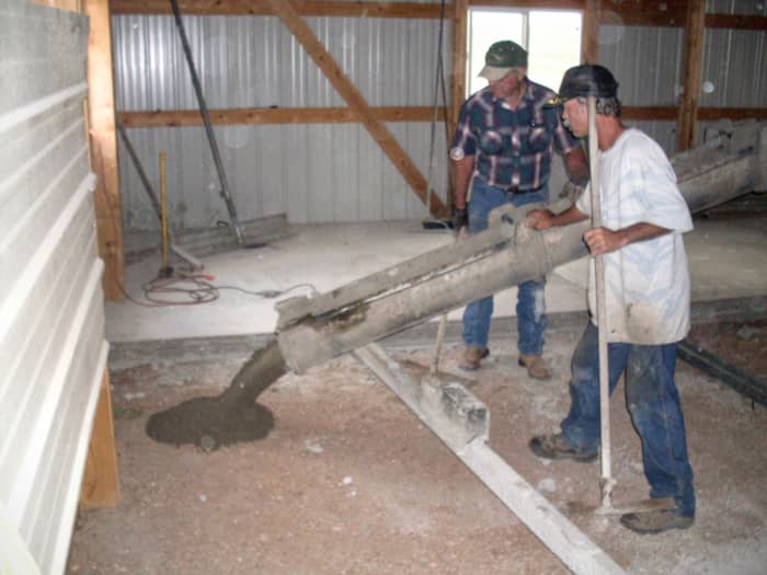The concrete pour is started in the back of the building. My husband helps direct the flow of the concrete, keeping it well within the appropriate section.