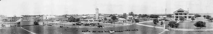 Panoramic view of the 101 ranch showing farm buildings, residences, ranch hands, farm machinery, and animals.