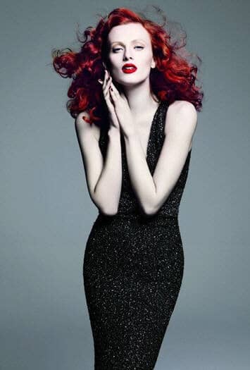 St John advertisement with glamorous red head wearing a black evening gown