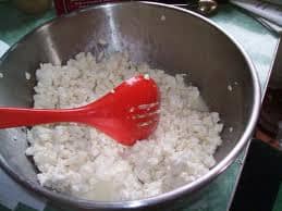 Sprinkle the salt and blue-mold powder blend over the curds and mix them together with a slotted spoon or your hands