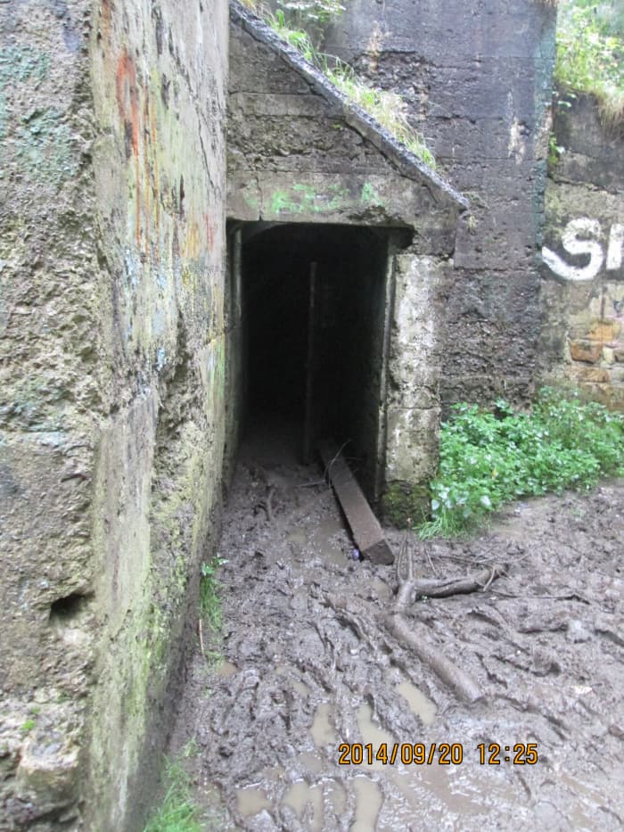 The way in - clamber over a concrete post that lies in front of the steel door, and the 'clag' around it, find your feet in the half dark. Not advisable to go beyond the round brick arch inside. One or two nervy tour members refused to come in
