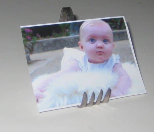 Fork picture frame. This bent fork could also be used to hold a recipe card in the kitchen or any paper that is small and sturdy.