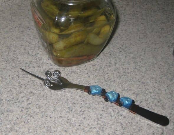 Fork with all but one tine curled leaving one pointy tine perfect for picking up pickles and olives. The handle is wire wrapped with cat beads.
Photo by Peggy Hazelwood.