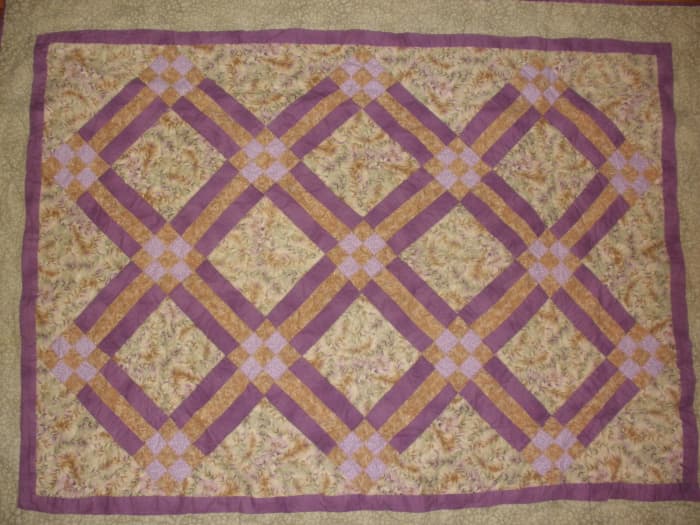 This traditional quilt uses rail fence blocks and nine patch blocks in a diagonal setting.