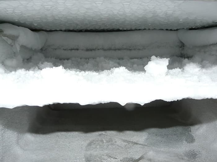 Frost buildup inside a freezer. The frost building up on the coils acts as an insulator and slows the rate at which heat can be removed by the compressor.