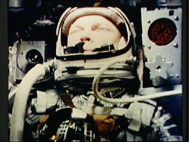 Photo of John Glenn taken during Friendship 7 mission shows hoses attached to either side of the helmet, one for venting carbon dioxide, and one to help seal the faceplate when closed. Photo courtesy of NASA.