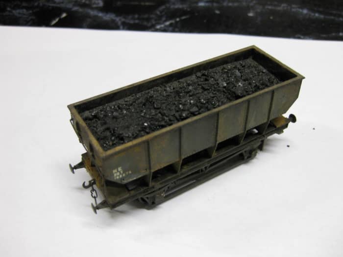 This is one of my own re-worked Dapol 21 ton LNER steel-built mineral hoppers with de-mountable load. Basically 2.5mm plastic card, layered, painted, PVA-spread, sprinkled with real coal granules. Raised to height with plastic blocks added to ends