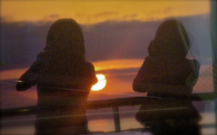 Two women shooting the sunset with their telephoto lenses as the Prinsendam sails in late afternoon.