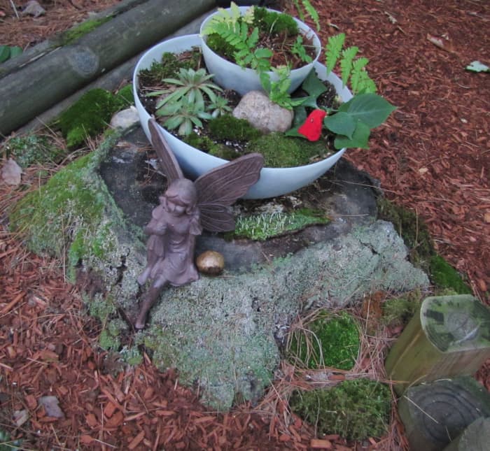 Here I used a discarded set of plastic lamp shades. After adding dirt, I put moss and a fern in to form the garden.
