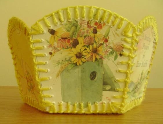This is a side view of a basket I made out of recycled greeting cards and coordinating yellow yarn.