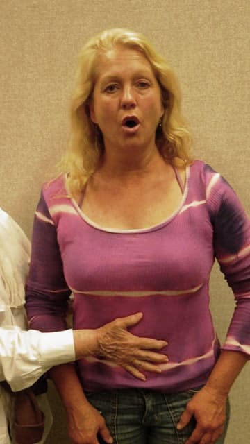 Inhale by inflating the lower ribcage and abdominal wall. Do this simultaneously. Notice where my hand is placed in the photo. Breathe through the nose to inhale and exhale slowly through the mouth. Use a hissing sound.