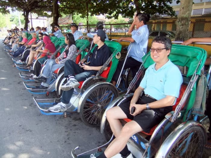 Street Photo in Hoi An, Vietnam: Our office had 65 cyclos to take us around Hoi An, giving business opportunities to these drivers