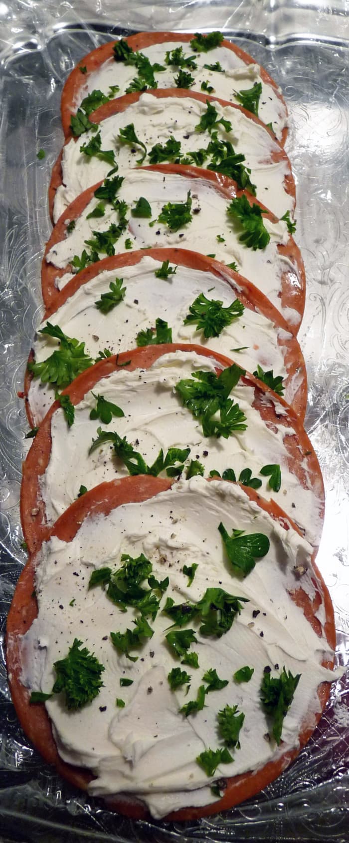 Try to spread approximately the same amount of cream cheese on each slice of salami so the pinwheels look nice and even when cut.