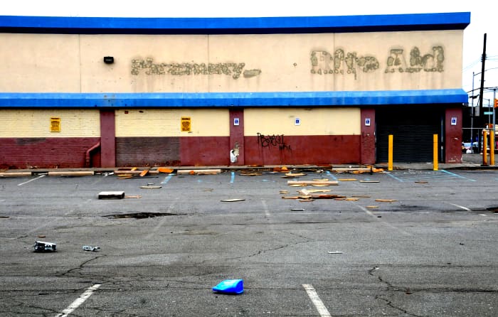An abandoned store, with obvious signs of decay. A bad neighborhood is one where businesses move out of.