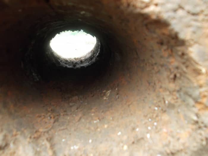 The deepest hole faces the outside world. Hopefully embers won't travel its full depth. We removed the plastic pipe so it won't melt or release toxic fumes. The wire mesh stayed soundly in place.