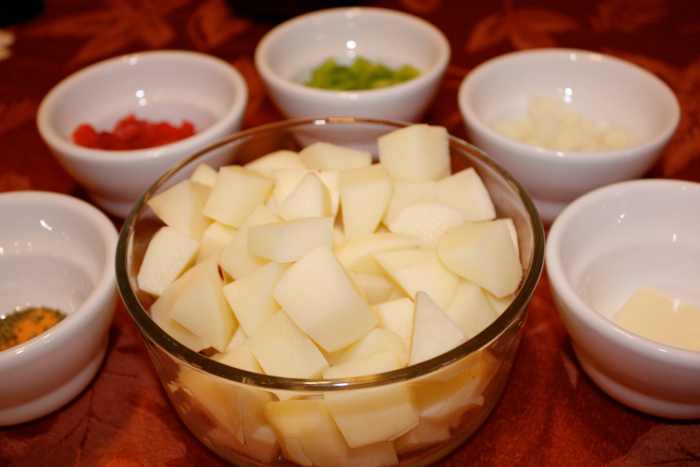 All ingredients except canola oil: potatoes, green bell pepper, red bell pepper, onion, butter, seasoning salt, parsley flakes, and garlic powder.