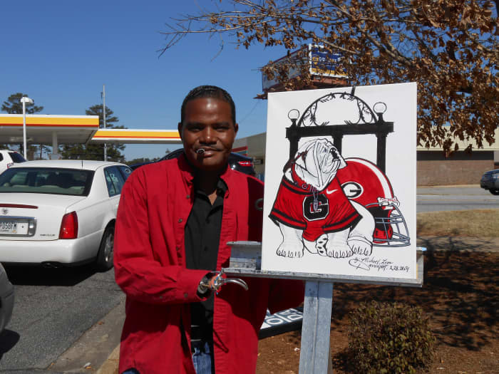 Davenport with the finished product. He typically asks customers to apply a glossy coat to the canvas to preserve the drawing.