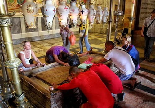 Stone of Anointing which tradition claims to be the spot where Jesus' body was prepared for burial by Nicodemus and Joseph of Arimathea. The stone greets you to Sepulcher at the entrance. (Station 13)