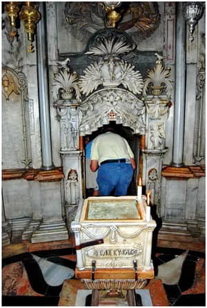 First chamber of Jesus' tomb. The first chamber is called the "Chapel of the Angel". A fragment of the covering stone of the Sepulcher is placed right behind the man who is entering the tomb.