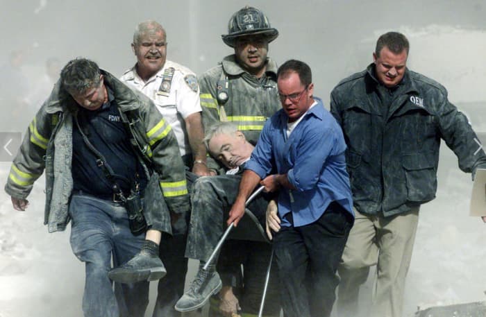 Rescue workers carry mortally injured New York City Fire Department chaplain Fr. Mike Judge from the wreckage after he was killed by falling debris while administering last rites to another victim.