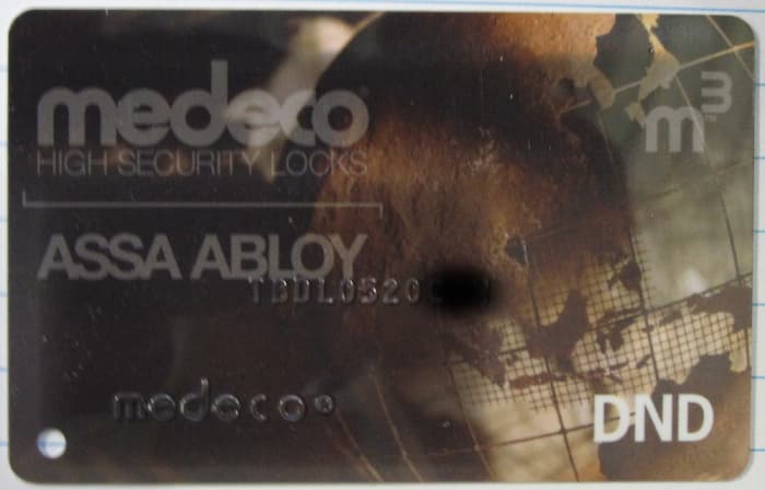 Medeco restricted key authorization card, number partially masked. No card, no key.