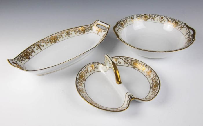 The single center handle is just over 8 inches wide. The round bowl is just over 9.75 inches wide from handle to handle. The long dish/tray is just over 13 inches long from handle to handle.